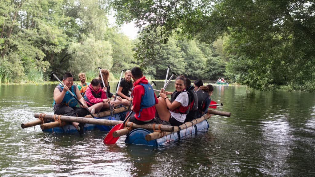 Teens taking part in an exciting raft-building activity at an English summer camp, developing teamwork and communication skills as part of our English courses for international students in the UK.