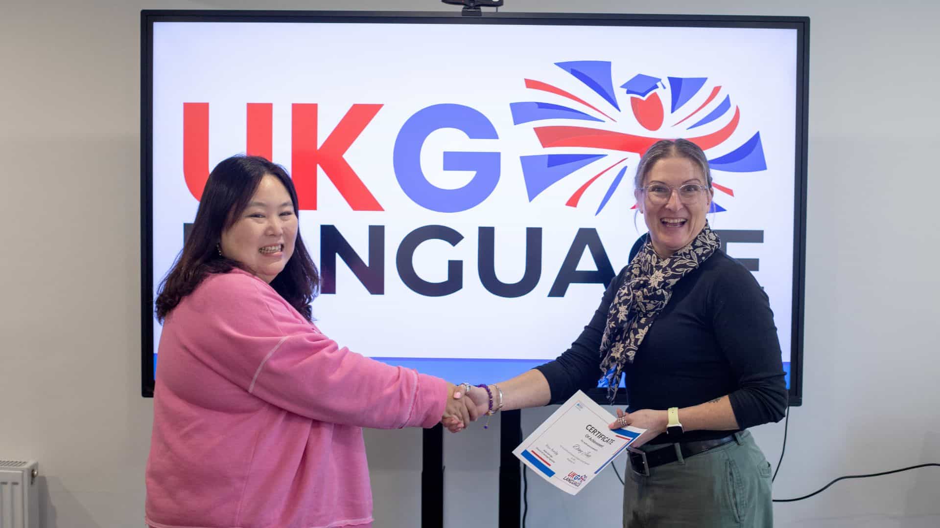 Person shaking hands with the Headteacher at UKG Education after successfully securing a new job position.